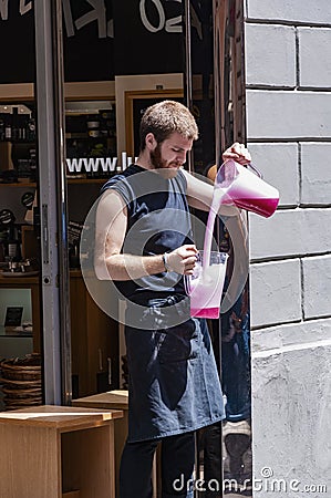 barista carefully pours liquid from one container to another one Editorial Stock Photo