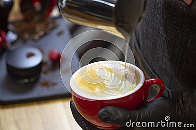 Barista makes latte art drawing on cappuccino coffee Stock Photo