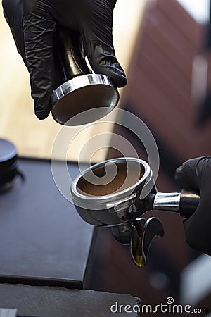 Barista making presses the coffee in the portafilter with temper Stock Photo