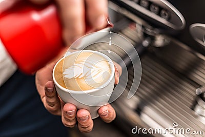 Barista pouring milk Stock Photo