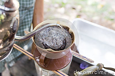 Barista pouring water on coffee ground with filter outdoor Stock Photo