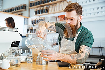 Barista pouring water in glass Stock Photo