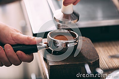Barista pressing coffee in the machine holder Stock Photo