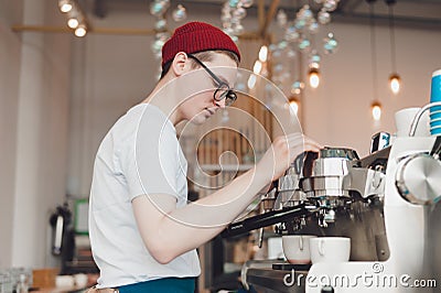 Barista stands behind the coffee machine and makes coffee Stock Photo