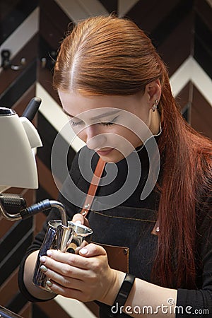 Barista steaming milk at the coffee machine at the coffee shop Stock Photo