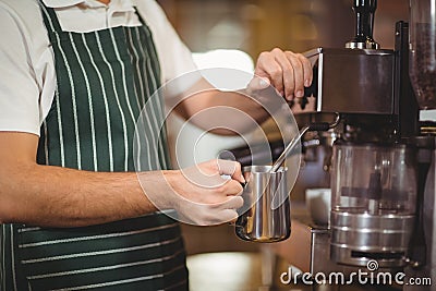 Barista steaming milk at the coffee machine Stock Photo