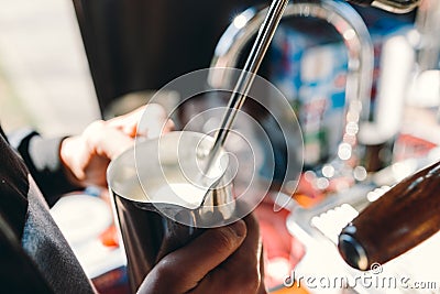 Barista steaming milk in coffee shop Stock Photo