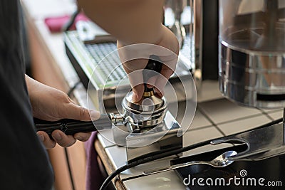 Barista tamped ground coffee in a portafilter Stock Photo
