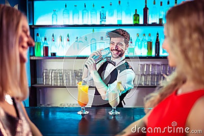 Barkeeper preparing cocktail for female customers Stock Photo