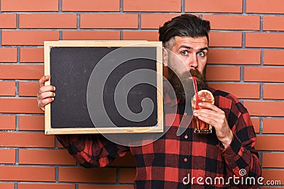 Barman with beard and pensive face drinks cocktail Stock Photo