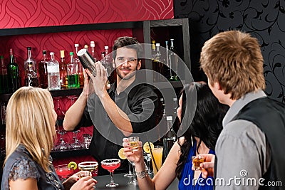 Barman cocktail shaker friends drinking at bar Stock Photo