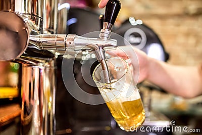 barman hands at beer tap pouring a draught lager beer serving in a restaurant or pub Stock Photo