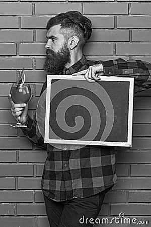 Barman, hipster holds cocktail and advertising. Man holds glass Stock Photo