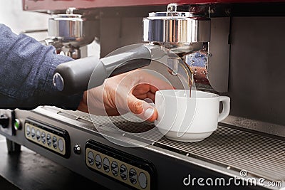 Closeup of barmen hand brewing espresso in professional coffee machine Stock Photo