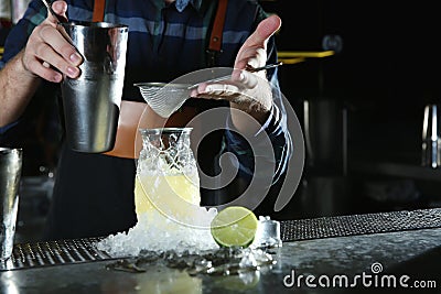 Barman making tropical cocktail at counter in pub, closeup. Stock Photo