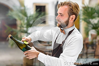 Barman opening bottle with sparkling wine Stock Photo