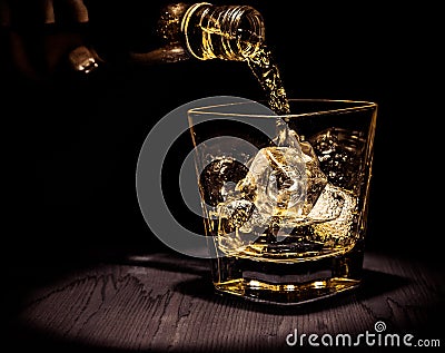 Barman pouring whiskey in the glass on wood table, warm atmosphere, old style, time of relax with whisky Stock Photo