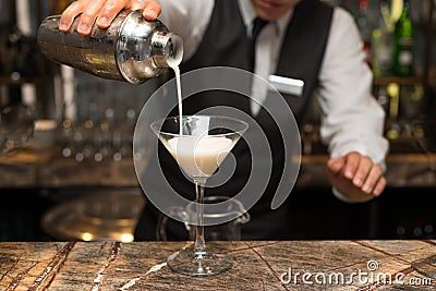 Barman at work, preparing cocktails. pouring pina colada to cocktail glass. Stock Photo