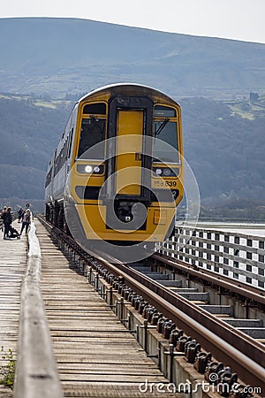 BARMOUTH, GWYNEDD UK - APRIL 09 : Train travelling over the viaduct in Barmouth, Gwynedd on April 09, 2023. Unidentified people Editorial Stock Photo