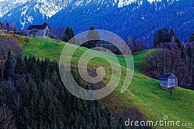 Barns on hill in mountainous landscape by dusk in winter Stock Photo