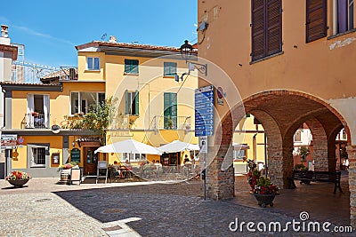 Barolo streets, arches and sidewalk restaurant in a sunny summer day in Italy Editorial Stock Photo