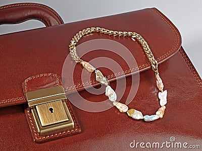 Baroque pearl golden chain necklace on male brown leather case Stock Photo