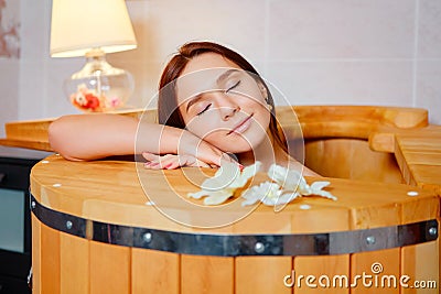 Barrel cedar. Wellness spa sauna. Aromatherapy treatment. Young beauty woman. Girl face Stock Photo