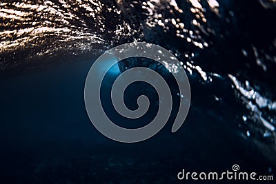 Barrel wave in ocean with warm sunset or sunrise tones. Underwater background with surfing wave Stock Photo