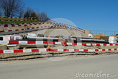 Barrier planks of red and white colors serving as a fence on a large civil engineering building place. Stock Photo