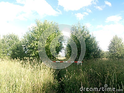 Barrier in red - white stripe in the grass. No entry Stock Photo