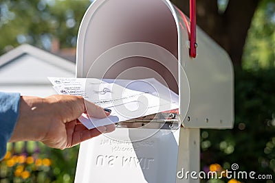 Barrington, IL/USA - 08/22/2020: Woman taking applications for mail in voting out of home mailbox Editorial Stock Photo