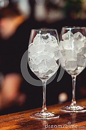Bartender cooling out cocktail glass with ice Stock Photo