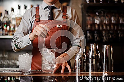 Bartender cooling out Cocktail glass mixing ice with a spoon Stock Photo