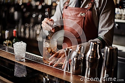 Bartender cooling out Cocktail glass mixing ice with a spoon Stock Photo