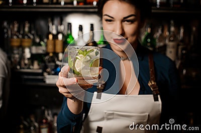 Bartender girl holding an fresh cocktail with lime and mint Stock Photo