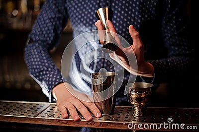 Bartender hand pouring a portion of pink alcohol drink into the shaker Stock Photo