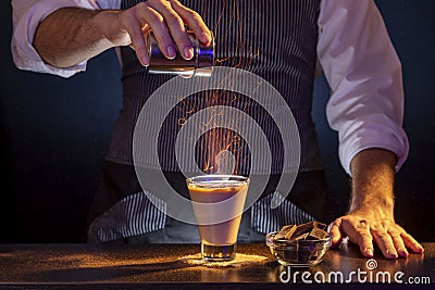 Bartender making Baileys comet cocktail on fire Stock Photo