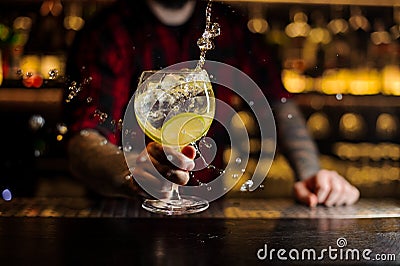 Bartender making splash of a delicious Gin Tonic cocktail with l Stock Photo