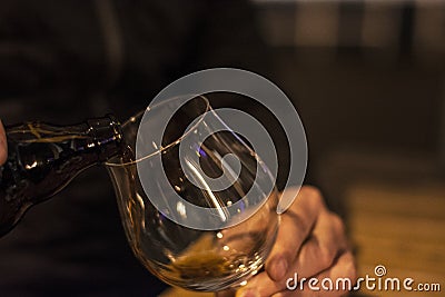 Bartender is pouring black beer in empty glass Stock Photo