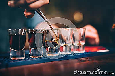 Bartender pouring and serving alcoholic drinks at bar Stock Photo