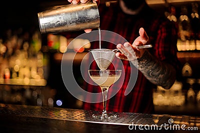 Bartender pourring a Daiquiri cocktail from the shaker through t Stock Photo