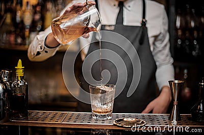 Bartender pourring a delicious alcoholic drink from a mixing glass Stock Photo