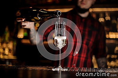 Bartender pourring a delicious champagne from a bottle to a glass Stock Photo