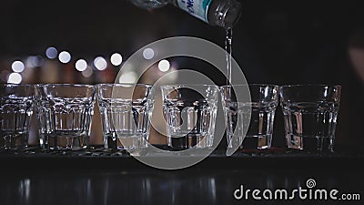 The bartender pours vodka into glasses Stock Photo