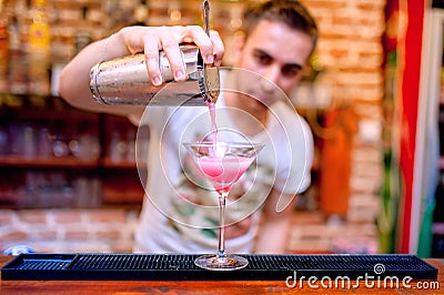 Bartender preparing and pouring cosmopolitan alcoh Stock Photo