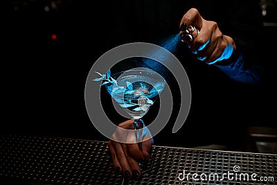 Bartender spraying cocktail with branch in blue light Stock Photo