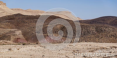 Basalt Hill with Prisms and Colorful Soils in the Makhtesh Ramon Crater in Israel Stock Photo