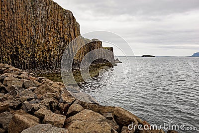 Basalt rocks and Stykkisholmsbaer circuit reflected in waters of an ocean near the city Stykkisholmur, Iceland Stock Photo