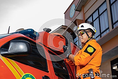 A Basarnas rescue team who is preparing and checking the equipment beside the car. Editorial Stock Photo