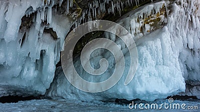 The base of the rock is covered with a thick layer of bizarre icicles and splashes. Stock Photo